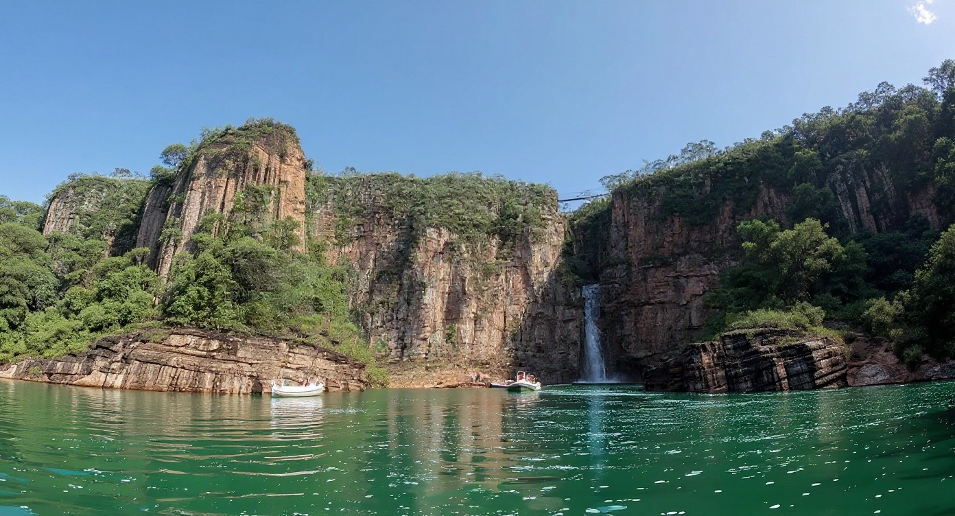 Imponente paisagem dos cânions de Capitólio, Minas Gerais, com paredões rochosos, cachoeira em cascata e águas verde-esmeralda, onde embarcações turísticas navegam. A imagem simboliza a beleza natural da região central para as discussões sobre segurança após o acidente de 2022 e a recente liberação de regras.